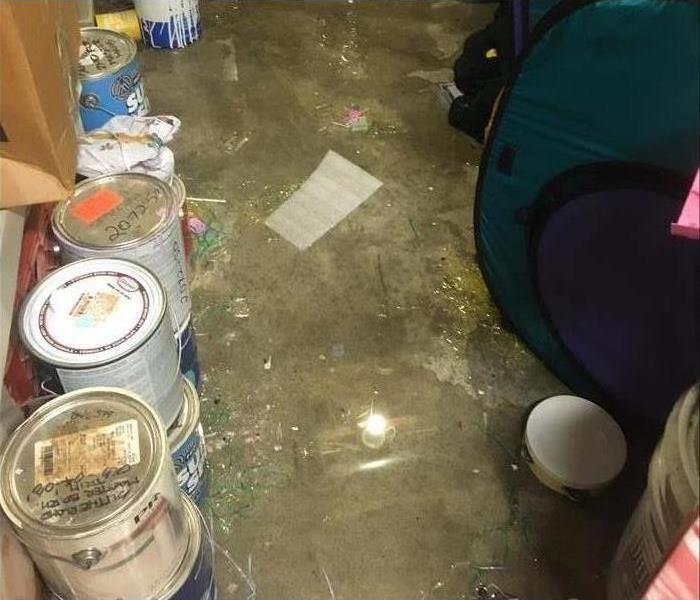 Wet floor, paint cans lined up. Concept of storm water intrusion in a home
